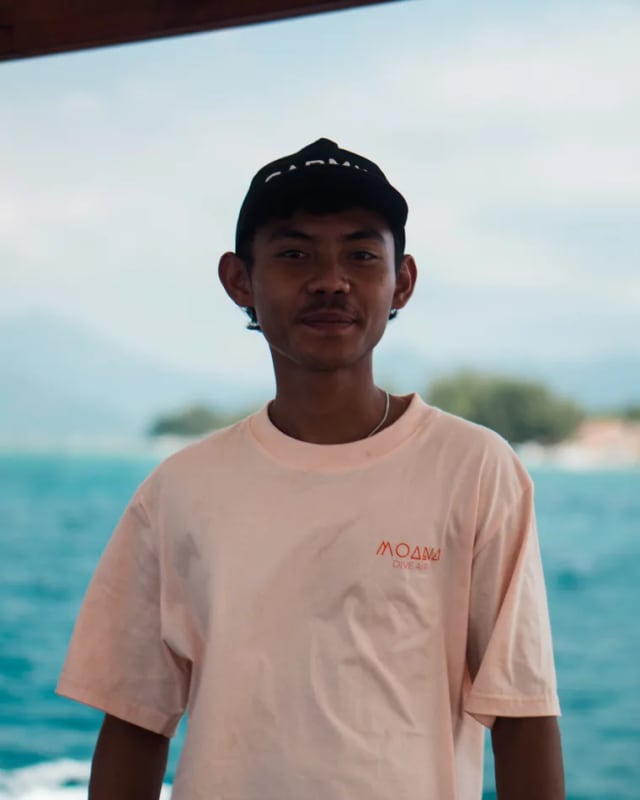 A Moana Dive Air guide in a Moana tee by the sea on Gili Air