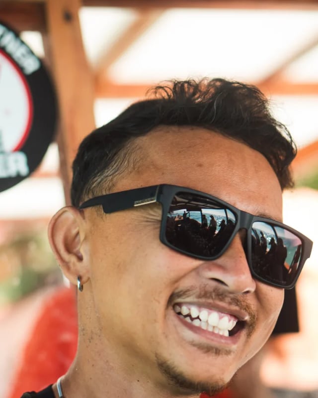 A smiling Moana Dive Air divemaster in sunglasses